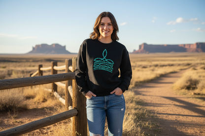 Person wearing black crewneck sweatshirt with turquoise southwestern design